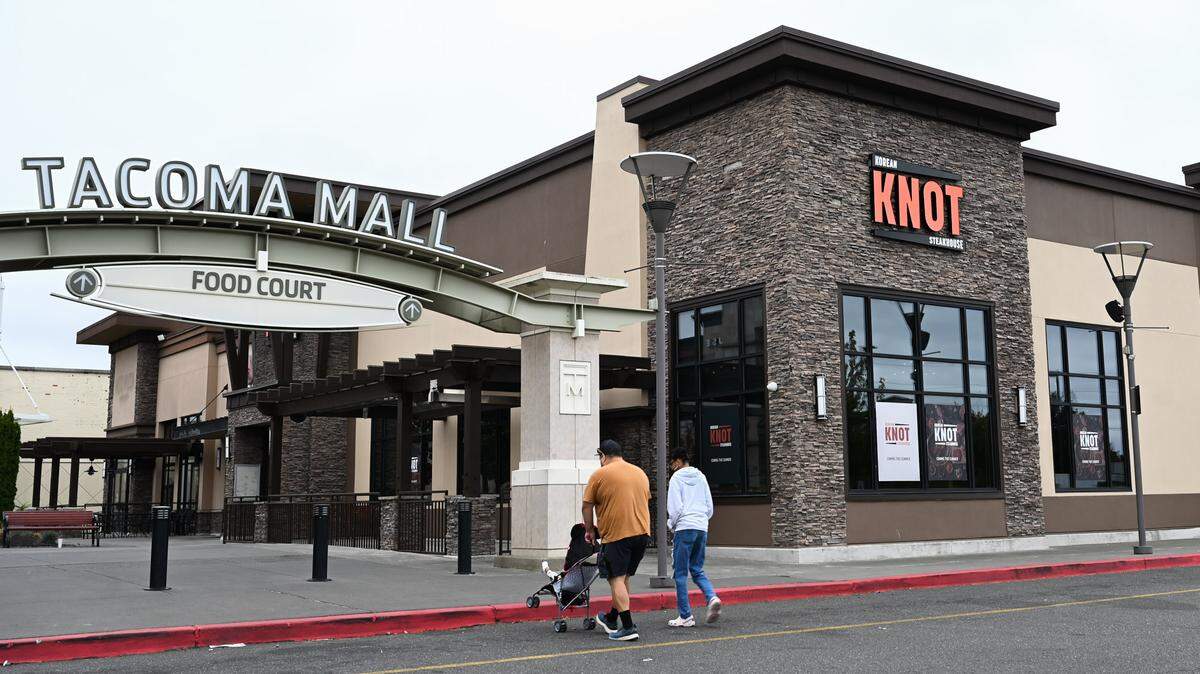 A family walks past Knot Korean Steakhouse as they head towards the Tacoma Mall on Tuesday, Aug. 6, 2024. The restaurant is expected to open early this fall.