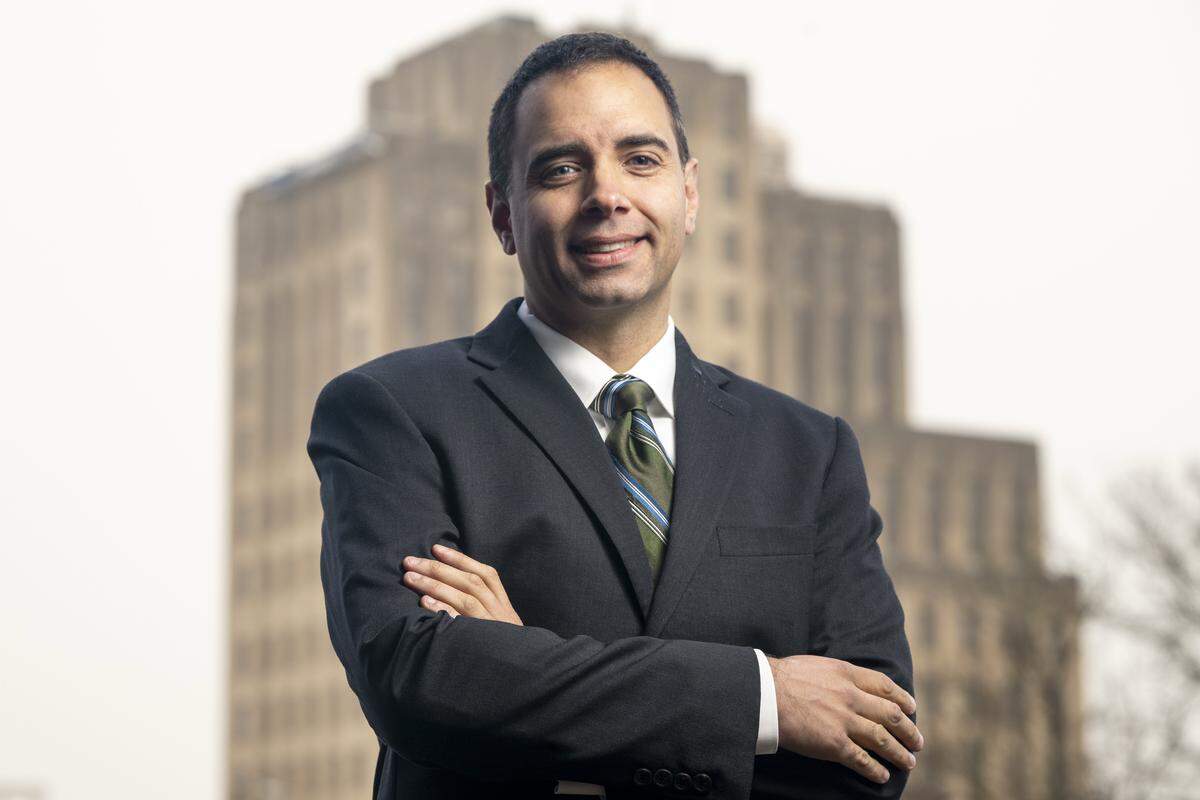 City Hall is pictured behind Tacoma Mayor-elect Anders Ibsen as he stands for a portrait on Friday, Dec. 5, 2025, in Tacoma, Wash.