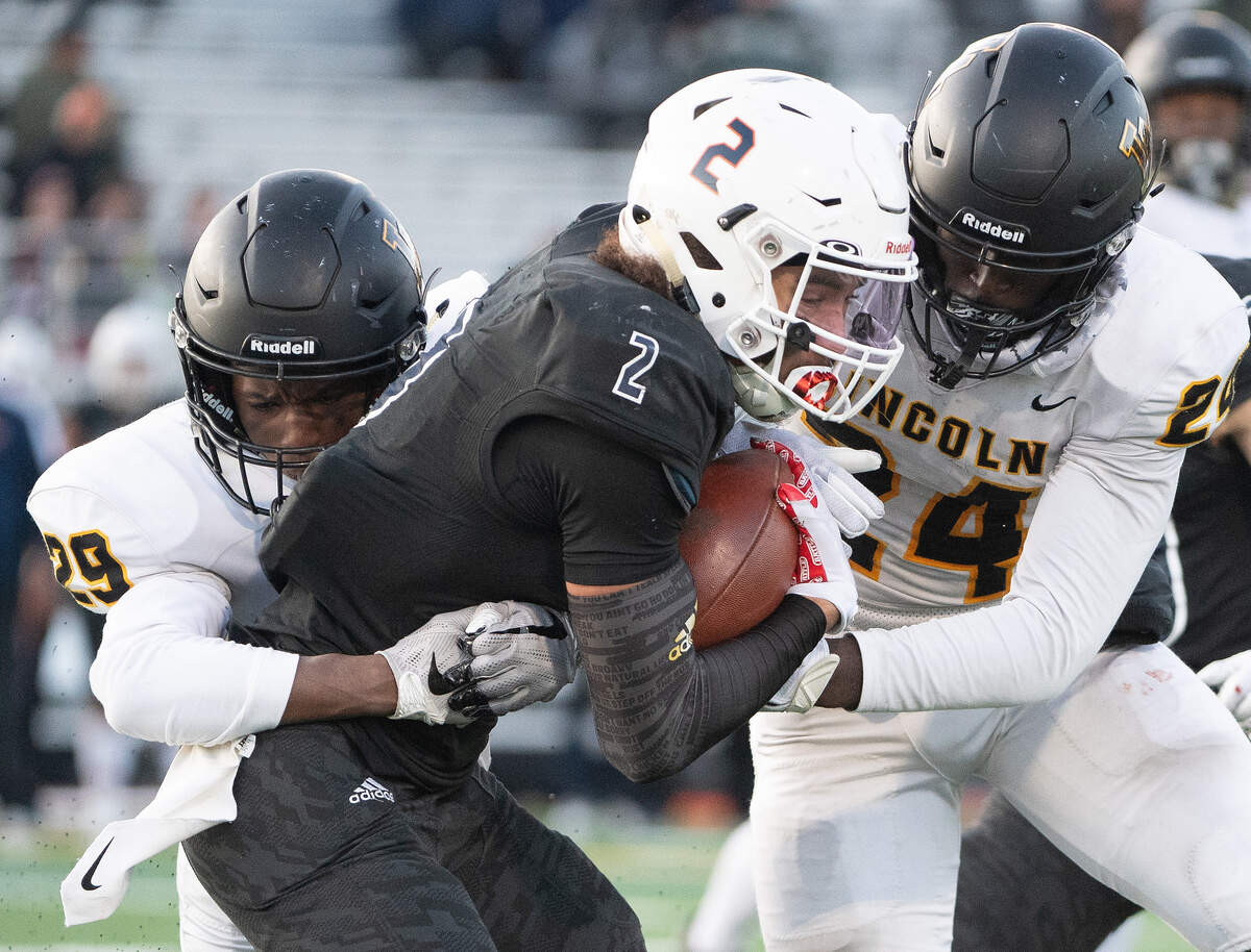 Lincoln’s Amarian Culpepper and Julien Simon tackle Eastside Catholic’s Sam Adams. Lincoln played Eastside Catholic in the 3A football semifinal game at Sammamish High School in Bellevue, Wash., on Saturday, Nov. 30, 2019.