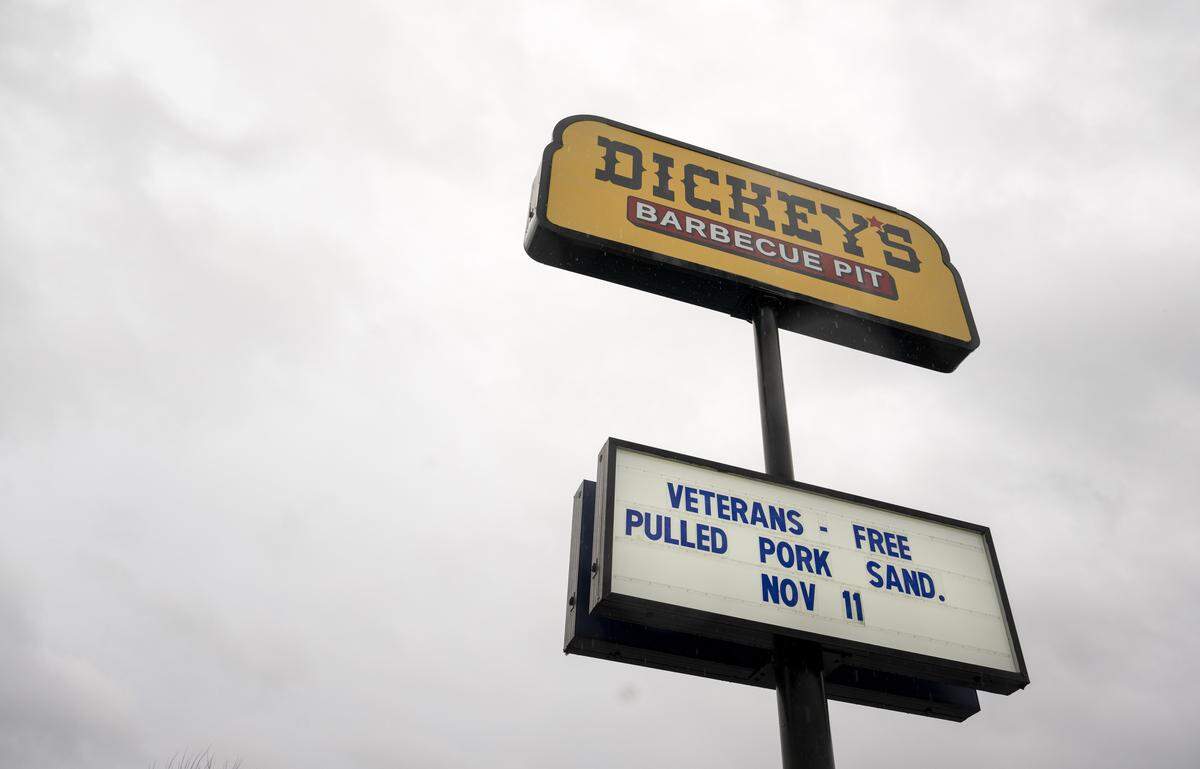 A sign outside of Dickey's Barbecue Pit promotes their Veteran's Day offerings from earlier in the week on Thursday, Nov. 13, 2025, in Puyallup, Wash.