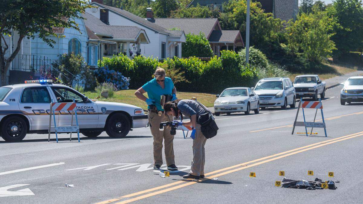 Officers with the Tacoma Police Department photograph evidence while investigating the scene near the Intersection of Pacific Avenue and S. 56th St. where a 39-year-old man was found with a gunshot wound at approximately 3 a.m. Sunday, July 18, 2021. He later died from his injuries at an area hospital.