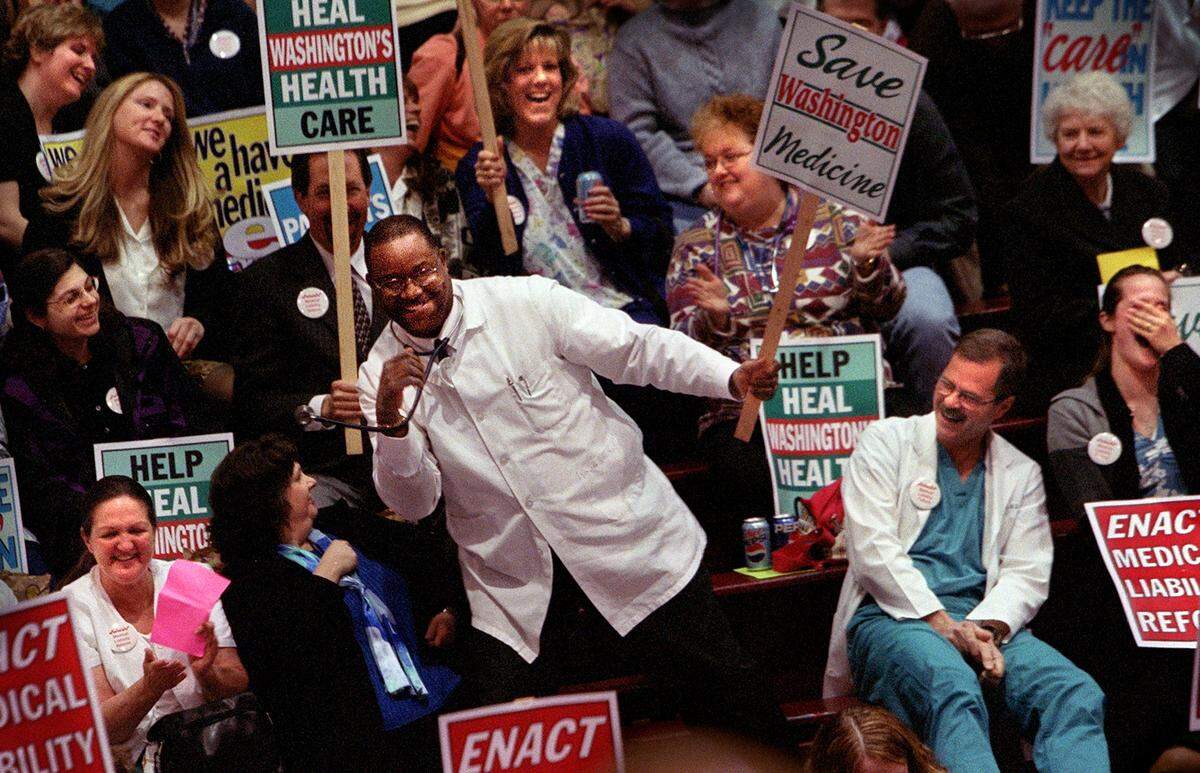 Dr. Charles Weatherby shows off his dance moves to the delight of fellow physicians and healthcare employees who assembled at the UPS Fieldhouse, April 9, 2003. About 600 people attended the rally to show support for medical liability reform that would limit the amount paid in malpractice cases.(Janet Jensen/The News Tribune)