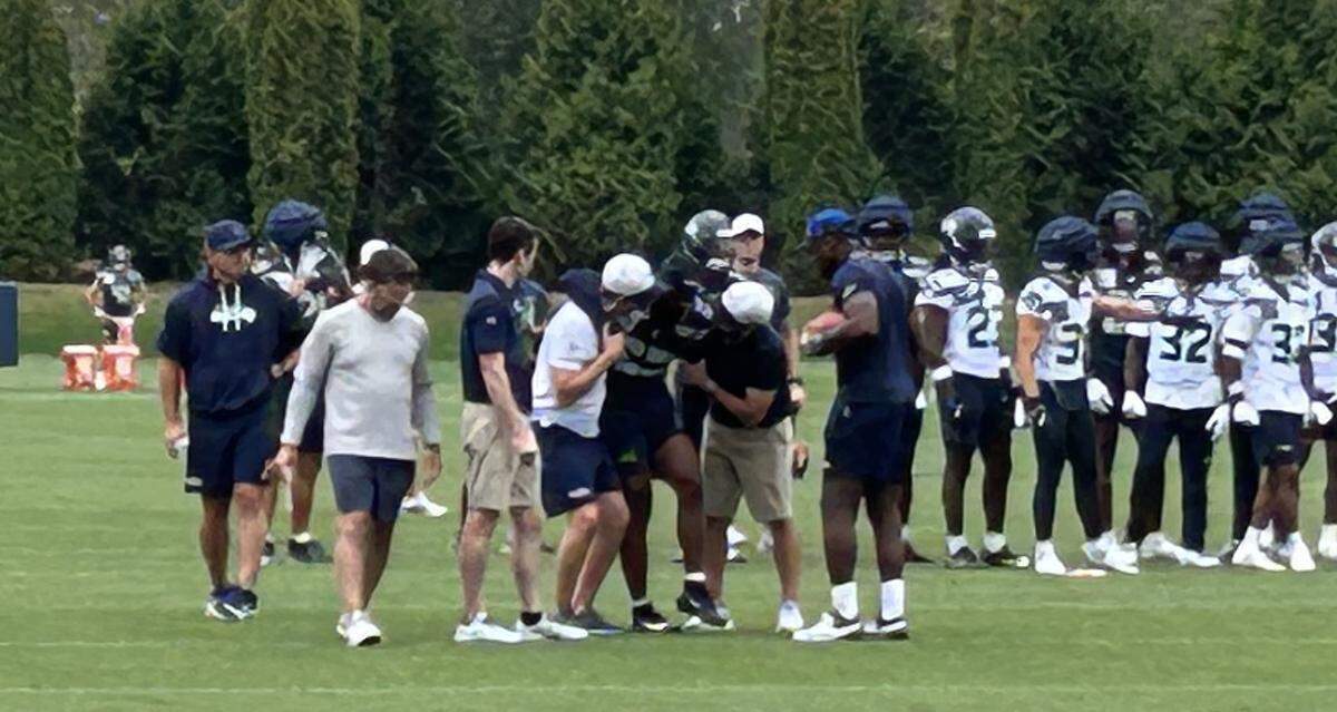 Running back Kenny McIntosh is carried off the field unable to put weight on his left leg because of a non-contact injury during special-teams drills in the fourth practice of Seattle Seahawks training camp Saturday, July 26, 2025, at the Virginia Mason Athletic Center in Renton. The team fears a torn ACL in his knee, a season-ending injury.