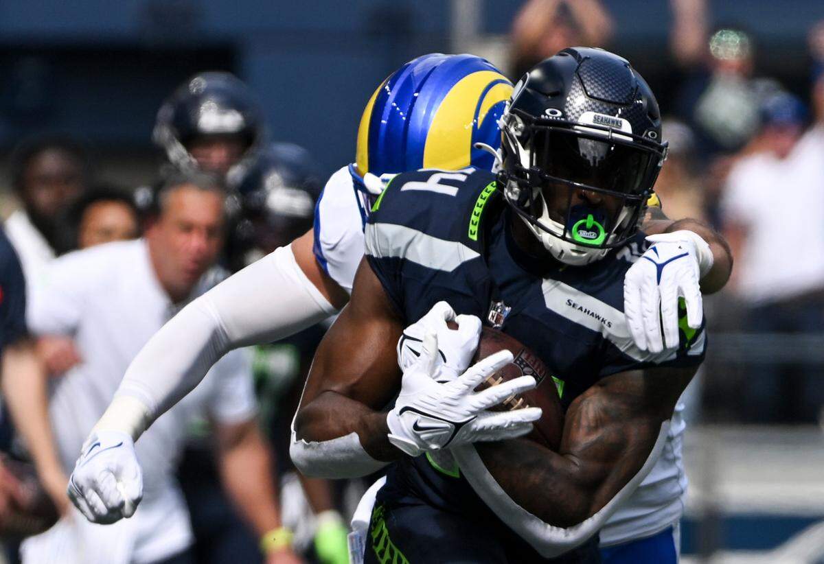 Seattle Seahawks wide receiver DK Metcalf (14) is wrapped up by Los Angeles Rams linebacker Michael Hoecht (97) during the first quarter of the NFL game at Lumen Field, Sunday, Sept. 10, 2023, Seattle, Wash.