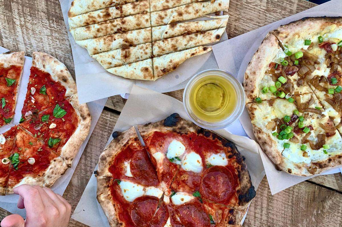 A spread of pies from Sirius Wood Fired Pizza, a food truck and catering company based in Puyallup, Washington. The truck parks Wednesdays at Acorn Brewing in Edgewood and Thursdays at Cockrell Cider, pictured here. Clockwise from left: Marinara, Roman Bianca, Flammkuchen, Margheroni.