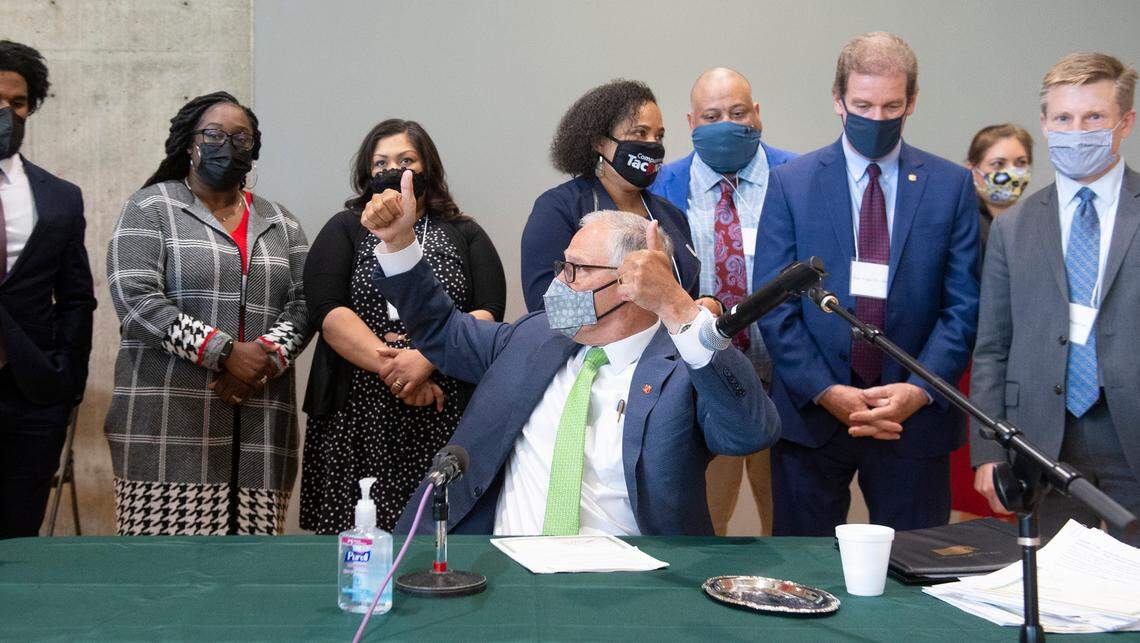Washington Gov. Jay Inslee throws two thumbs up after completing the signing of 12 bills about police accountability during ceremonies at the Eastside Community Center in Tacoma, Wash., on Tuesday, May 18, 2021.
