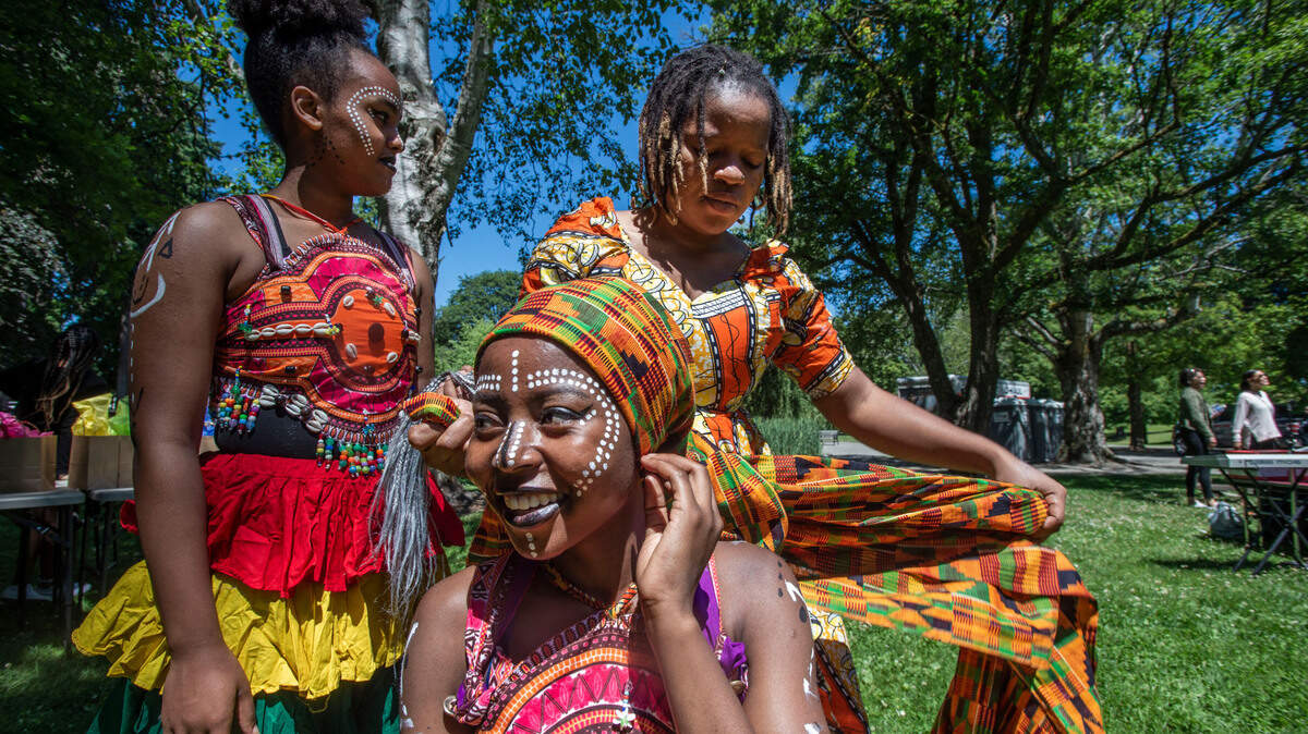 A troupe of dancers with the Tacoma Urban Performing Arts Center (T.U.P.A.C.) prepare to perform some traditional Ghanian numbers at the 2nd Annual Still We Rise! Juneteenth Celebration in Tacoma’s Wright Park on June 19, 2021. The new federal holiday commemorates the end of slavery in the United States after the Civil War on June 19, 1865. From left: Hana Carlson, Sophia Bajinya and Sheimawu Abubakari.