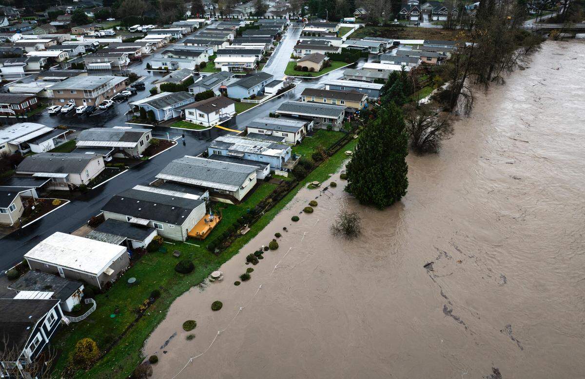 Water flows over the banks of the Puyallup River near the Golden Rose 55+ Community in Puyallup on Wednesday, Dec. 10, 2025.