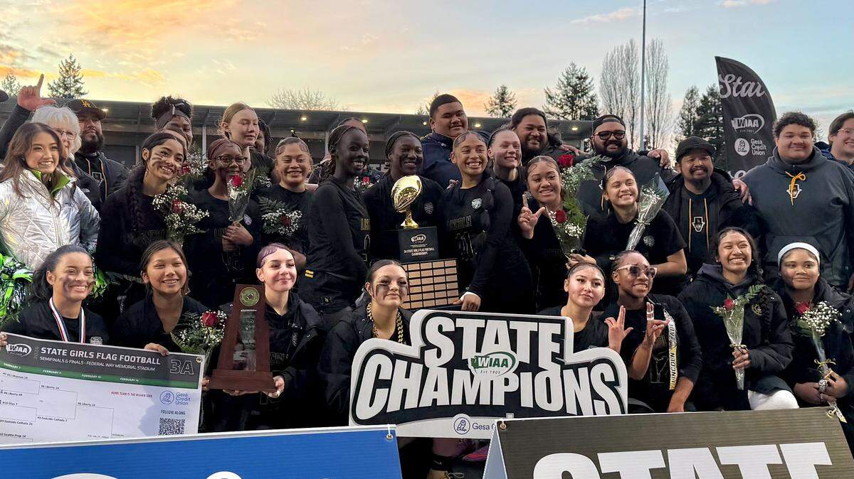 No. 1 Lincoln’s girls flag football team poses for a portrait with the championship trophy after beating No. 10 Seattle Prep, 21-14, in the 3A state title game at Federal Way Memorial Field on Feb. 14, 2026, in Federal Way, Wash.