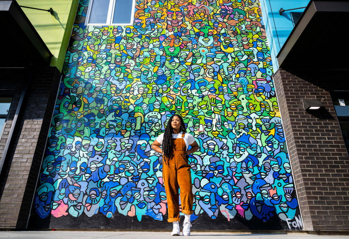 Local artist Tiffanny Hammonds poses for a portrait in front of a mural she painted on the side of the new Tacoma Housing Authority building at Earnest Brazill Street and MLK Way in Tacoma, on Oct. 6, 2022.