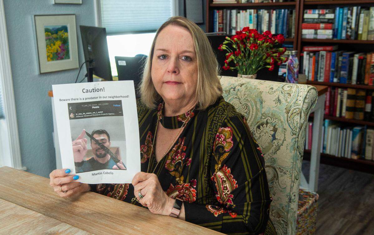 Lorri Smyth, president of the Westmore Homeowners Association in Puyallup, displays one of several fliers a neighbor distributed claiming resident Martin Cabello is a predator. The fliers, which were removed because they were frightening children, features a screen shot of Cabello brandishing a weapon in one of his numerous social media posts.