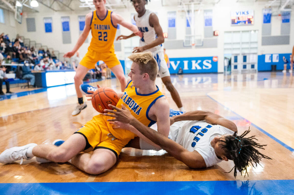 Tahoma’s Adam Davis (14) and Federal Way wing Vaughn Weems (0) fight for a loose ball along the baseline during the first quarter of a District 3/4 4A semifinal game on Friday, Feb. 17, 2022, at Curtis High School in University Place, Wash.