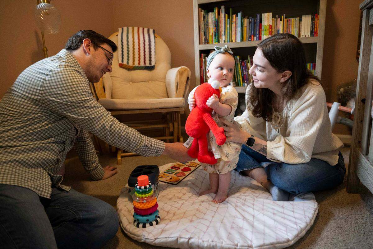 Abraham and Annie Thigpen play with their daughter Winona at home, on Wednesday, April 24, 2024, in Gig Harbor. In October 2023, parents Annie and Abraham were accused of abusing their then-5-week-old infant.
