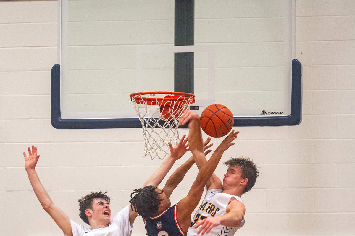 Life Christian guard Marquis Trimble (0) attempts a shot as Annie Wright guard Martin Kaupanger (21) and forward Jack Bryant (33) defend during the third quarter of a 1A Nisqually League game on Thursday, Feb. 10, 2022, at Annie Wright School in Tacoma, Wash.