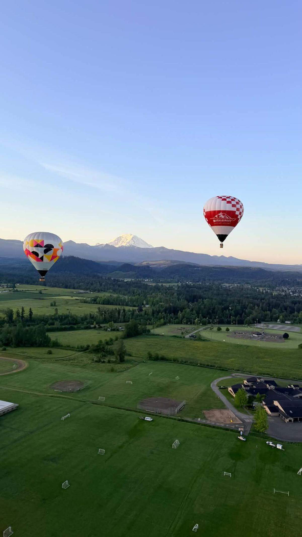 Two balloons from Seattle Ballooning flying with Mount Rainier in the background on May 27, 2026.