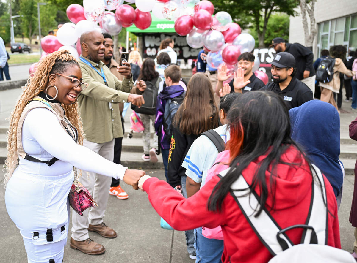 Students are greeted and given donuts by PUSH For Dreams, community leaders on the first day of school at Gray Middle School, on Monday, Sept. 9, 2024, in Tacoma, Wash.