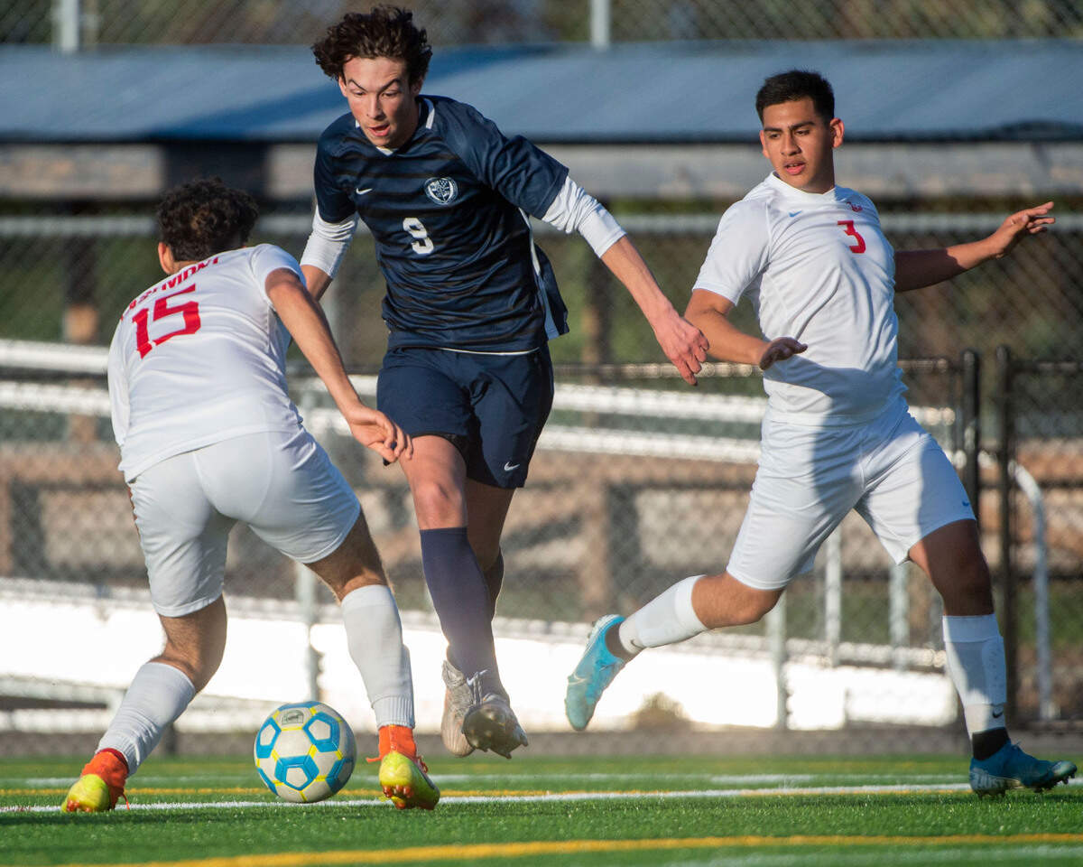 Bellarmine Prep Cael Tackett dribbles toward goal as Eastmont’s Luis Romero (15) and Mark Gomez (3) defend during the second half of a 4A State tournament first-round game on Wednesday, May 18, 2022, at Bellarmine Prep High School in Tacoma, Wash.