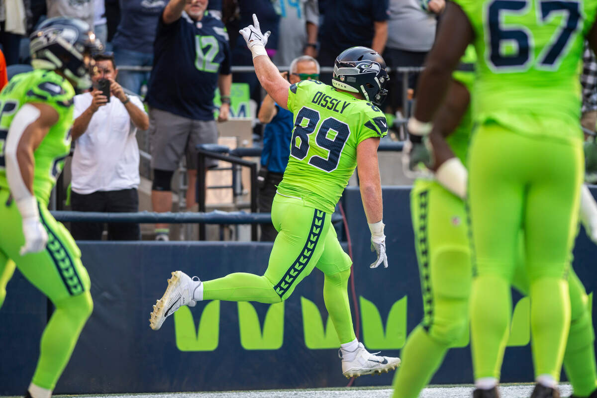 Seattle Seahawks tight end Will Dissly (89) holds his hand up and runs by fans after scoring the first touchdown of the game in the first quarter of an NFL game on Monday, Sept. 12, 2022, at Lumen Field in Seattle.