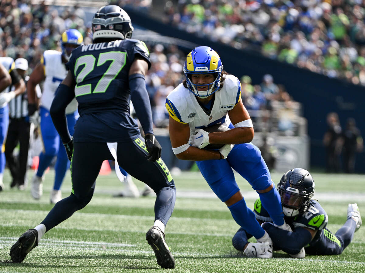 Los Angeles Rams wide receiver Puka Nacua (17) is trips up by Seattle Seahawks safety Julian Love (20) during the first quarter of the NFL game at Lumen Field, Sunday, Sept. 10, 2023, Seattle, Wash.