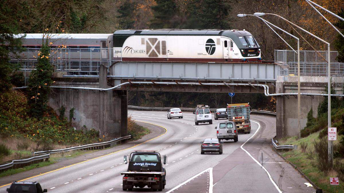 The northbound Amtrak Cascades train rolls across the Interstate 5 overpass in DuPont, Wash., in 2021.