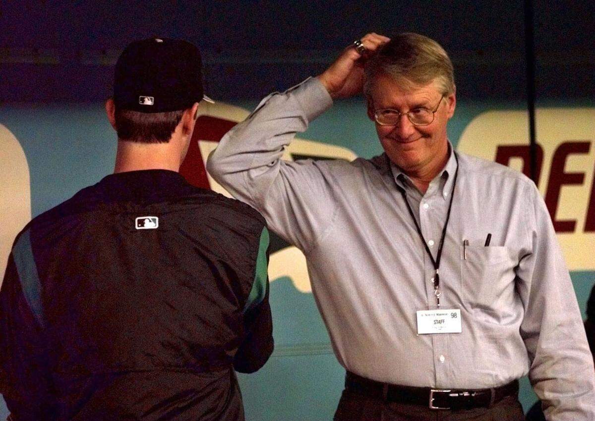 Seattle Mariners general manager Woody Woodward scratches his head as he talks with pitcher Jamie Moyer in the dugout before their game Friday, June 5, 1998 in Seattle.