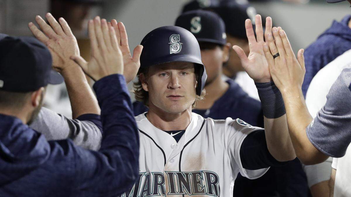 Seattle Mariners’ Gordon Beckham is congratulated after scoring against the Texas Rangers in a baseball game Tuesday, May 15, 2018, in Seattle. (AP Photo/Elaine Thompson)