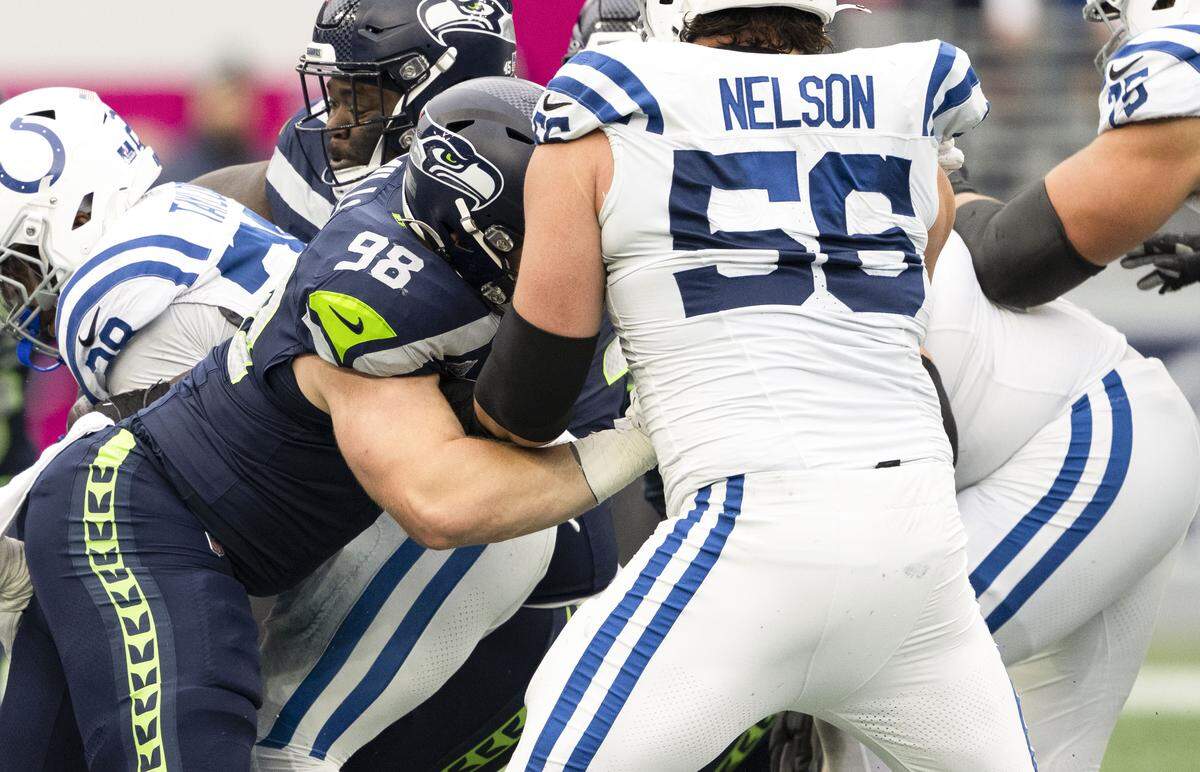 Seattle Seahawks defensive tackle Rylie Mills (98) crashes into Indianapolis Colts guard Quenton Nelson (56) in the game at Lumen Field, on Sunday, Dec. 14, 2025, in Seattle. It was Mills' first NFL game. The rookie from Notre Dame was out 12 months after he tore a knee ligament in a college football playoff game for Notre Dame in December 2024.