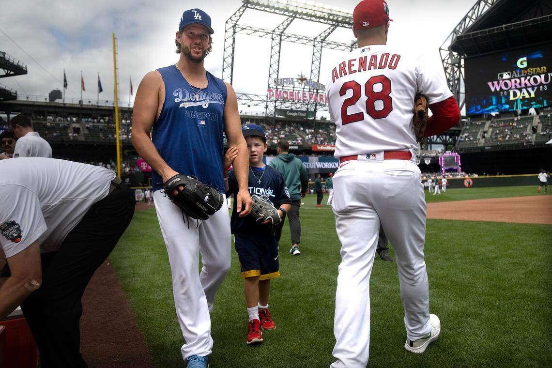 Clayton Kershaw and son, Charley, move through the media crowd during workouts before the All Star Home Run Derby in Seattle, Washington, on Monday, July 10, 2023.