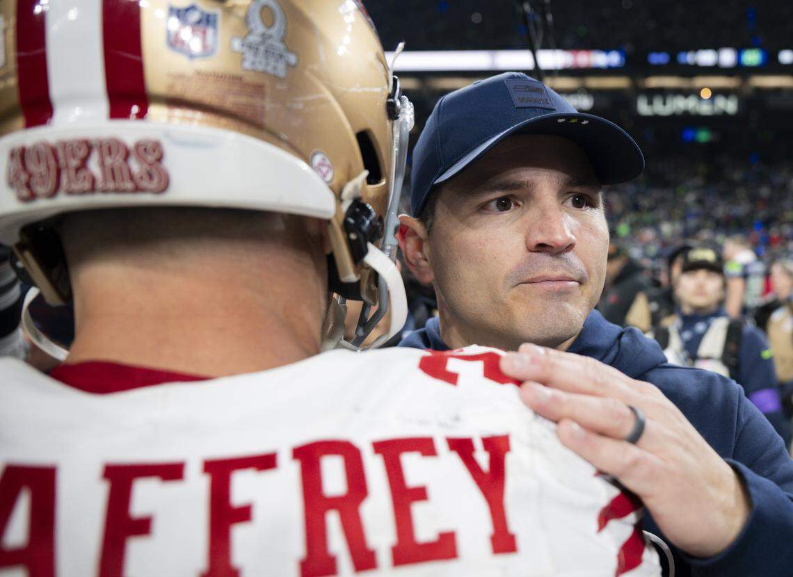 Seattle Seahawks head coach Mike MacDonald hugs San Francisco 49ers running back Christian McCaffrey (23) after the Seattle Seahawks 41-6 victory against the San Francisco 49ers the NFC Divisional Round game at Lumen Field, on Saturday, Jan. 17, 2026, in Seattle.
