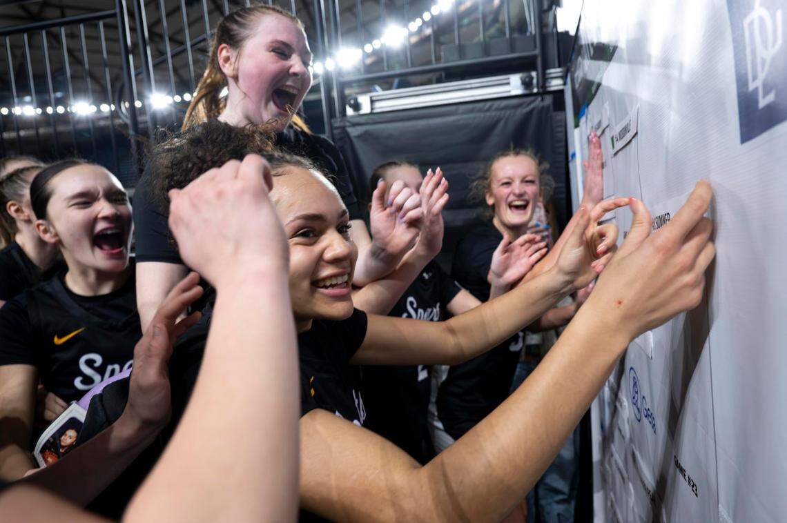 Guard Olivia Collins (10) puts the Sumner sticker on the finalist line on the large bracket after the Spartans beat Woodinville, 46-39, in a Class 4A state basketball tournament semifinal game at the Tacoma Dome on Friday, March 7, 2025, in Tacoma, Wash.