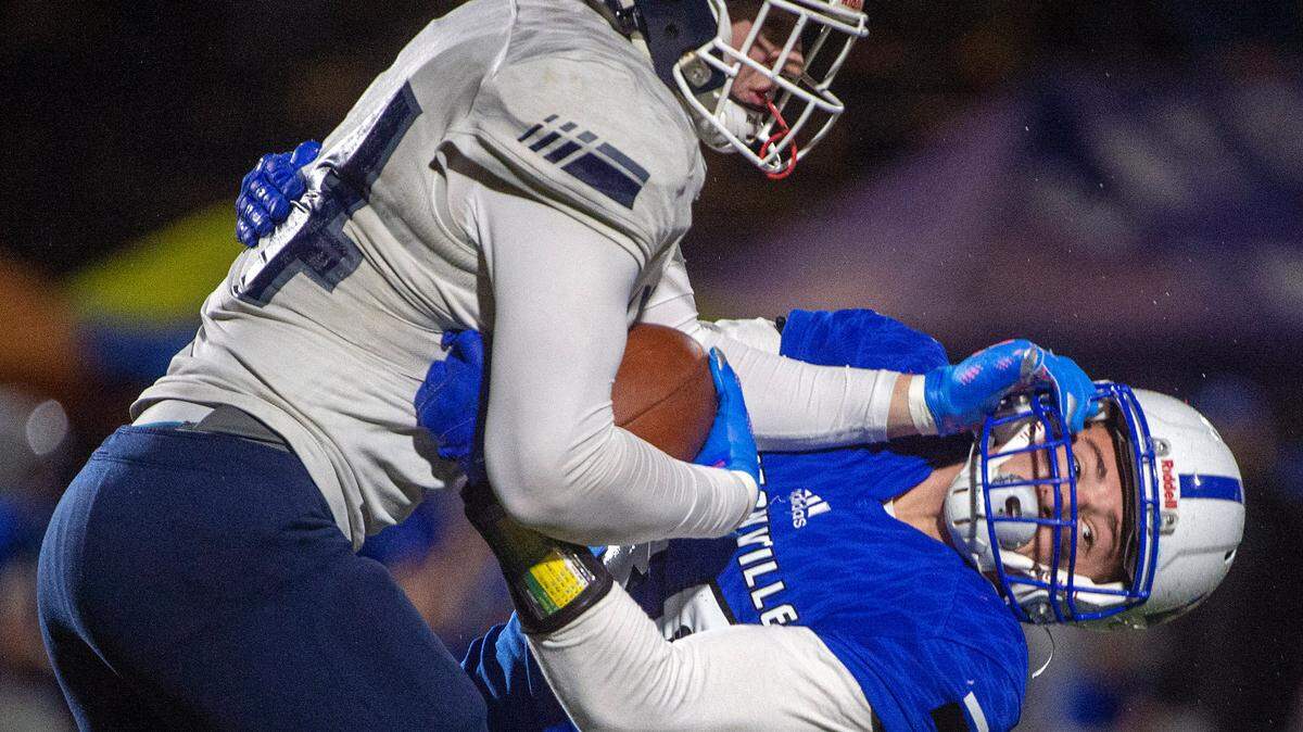 Lynden Christian tight end Kade Eldridge stiff arms Eatonville’s Zach Barnett during the first quarter of a State 1A semifinal game in 2021 at Art Crate Field in Spanaway.