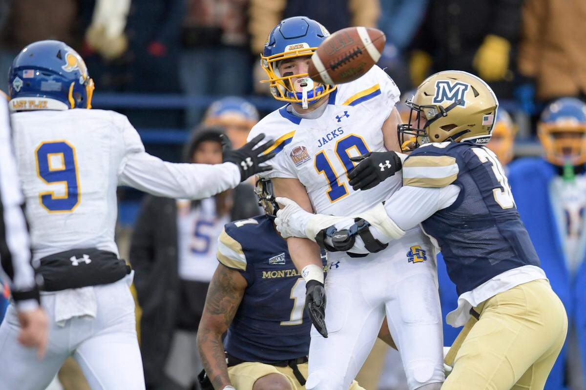 South Dakota State wide receiver Grahm Goering (18) fumbles the ball on a pitch from South Dakota State wide receiver Jadon Janke (9) while Montana State linebacker Danny Uluilakepa (30) tackles him in the second half of an NCAA college football game in the semifinals of the FCS playoffs, Saturday, Dec. 18, 2021, in Bozeman, Mont. The ball was recovered by Montana State. Montana State beat South Dakota State 31-17. (AP Photo/Tommy Martino)