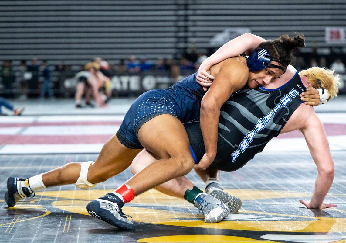 Kennedy Catholic Xe`Ree Alexander takes down Chiawana Lane Hedrick during the 220-pound 4A quarterfinal match at Mat Classic XXXIV on Friday, Feb. 17, 2023, at the Tacoma Dome in Tacoma, Wash. Alexander defeated Hedrick 11-4.