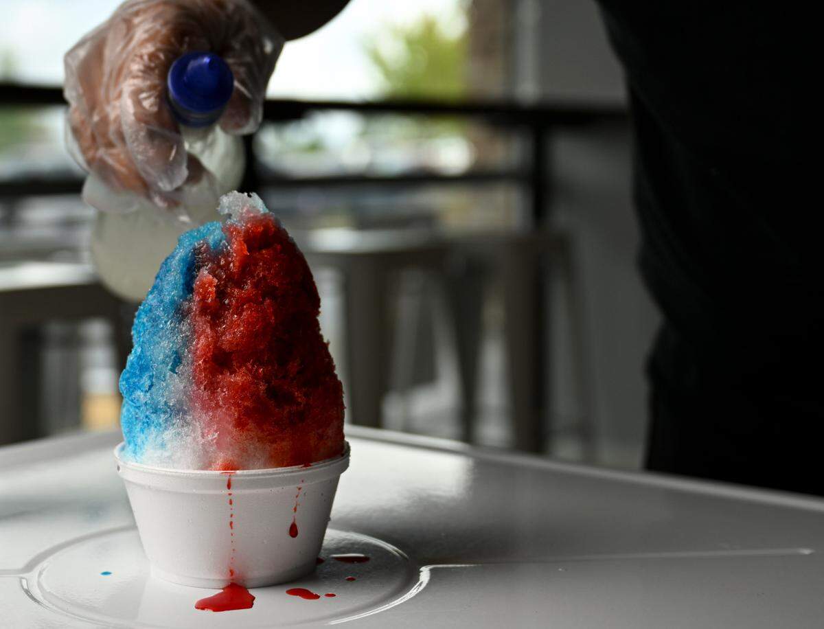 Let It Snow owner Sidoung Sok makes a red (strawberry), white (coconut) and blue (blue raspberry) Hawaiian shaved ice on Wednesday, Aug. 23.