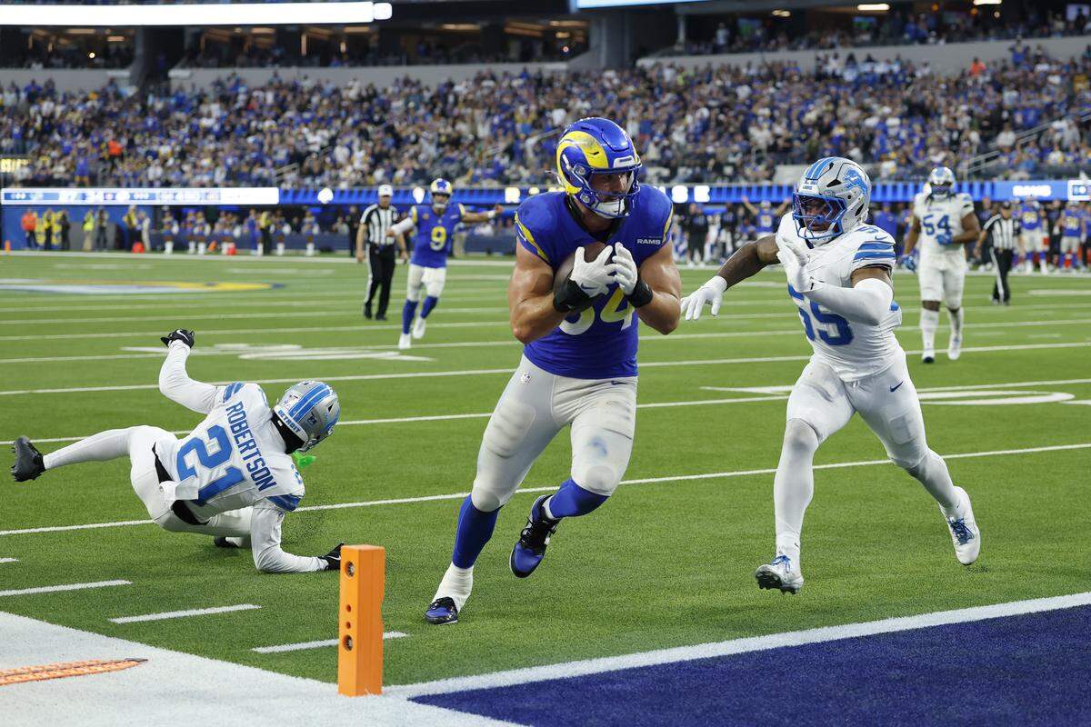 INGLEWOOD, CALIFORNIA - DECEMBER 14: Colby Parkinson #84 of the Los Angeles Rams scores a touchdown against Amik Robertson #21 and Derrick Barnes #55 of the Detroit Lions during the fourth quarter at SoFi Stadium on December 14, 2025 in Inglewood, California. (Photo by Harry How/Getty Images)