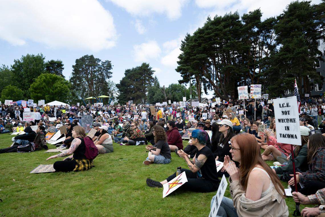People sit and listen to speakers during a No Kings” protest at People’s Park on Saturday, June 14, 2025, in Tacoma, Wash.
