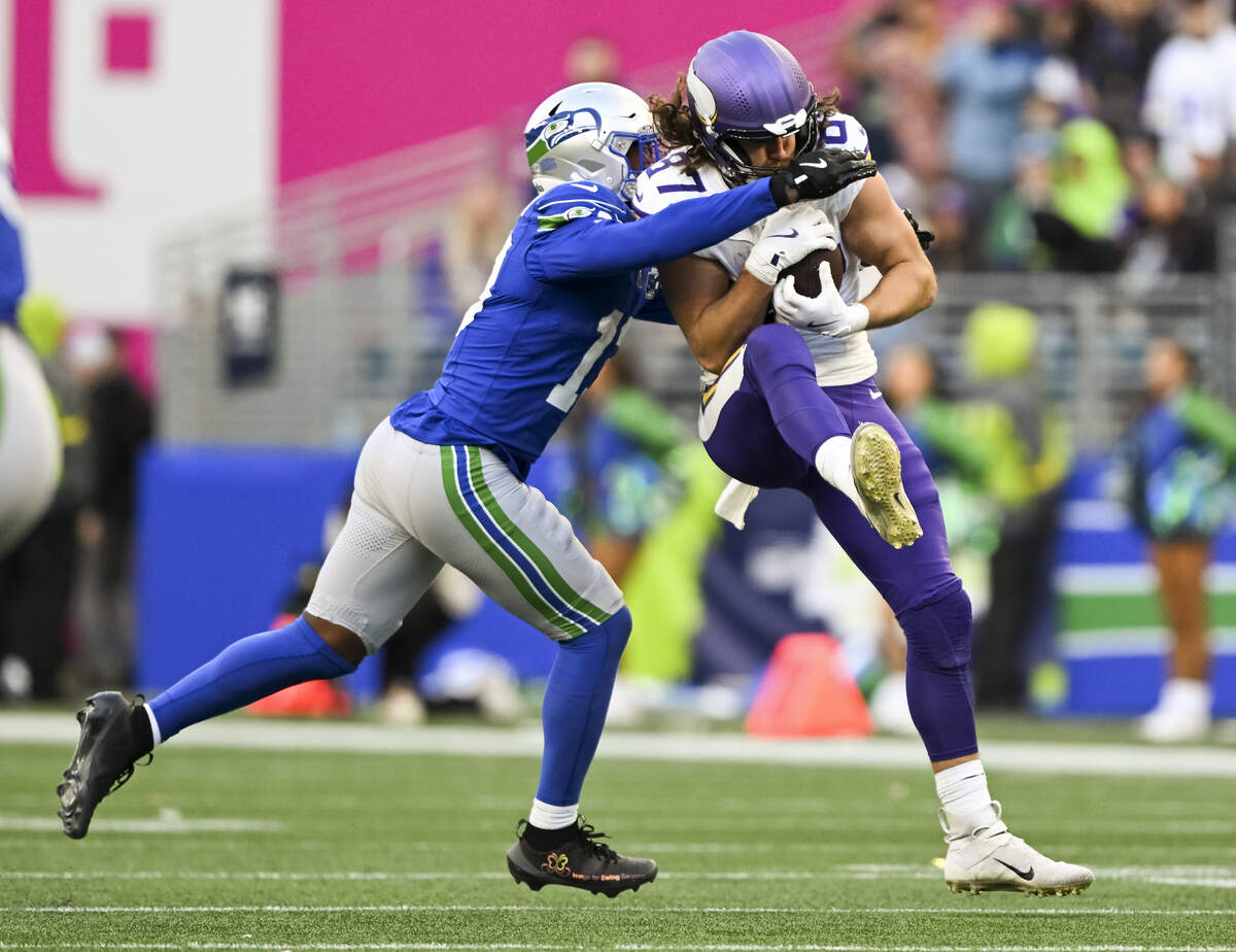 Seattle Seahawks linebacker Ernest Jones IV (13) hits Minnesota Vikings tight end T.J. Hockenson (87) as he makes a catch during the third quarter of the game at Lumen Field, on Sunday, Nov. 30, 2025, in Seattle.