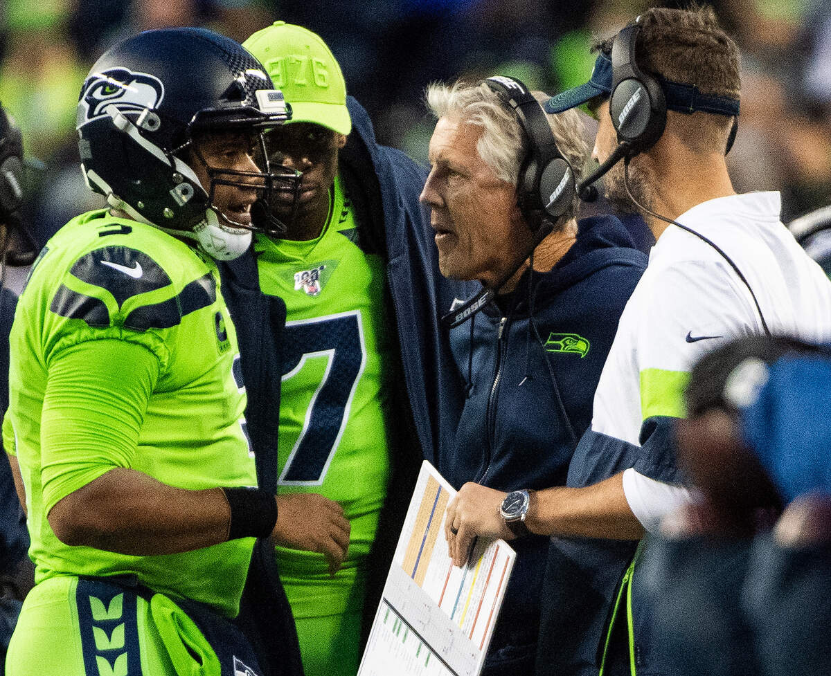 Seattle Seahawks quarterback Russell Wilson (3) chats with Seattle Seahawks head coach Pete Carroll and Brian Schottenheimer during the second quarter. The Seattle Seahawks played the Los Angeles Rams in a NFL football game at CenturyLink Field in Seattle, Wash., on Thursday, Oct. 3, 2019.