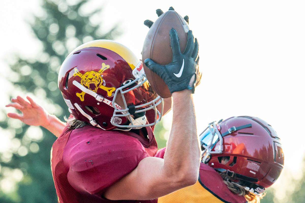 Enumclaw receiver Austin Paulson catches a pass over a defensive back during drills at practice on Wednesday, Aug. 24, 2022, in Enumclaw, Wash.