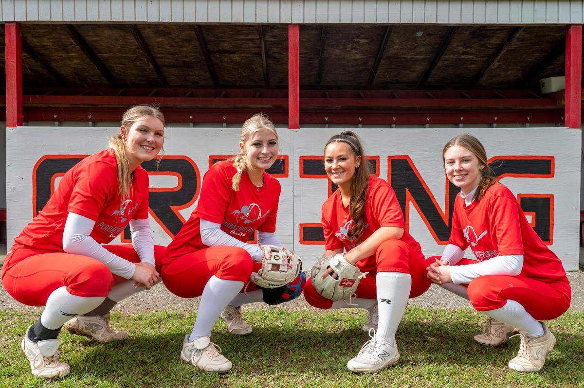 Orting High School softball players (from left) senior pitcher Kaylee Gresko, junior catcher Miken Jacobsen, senior shortstop Abbi Almont, and sophomore third baseman Madalynn Halte, pose for a portrait in Orting, Wash., on Monday, April 24, 2023.