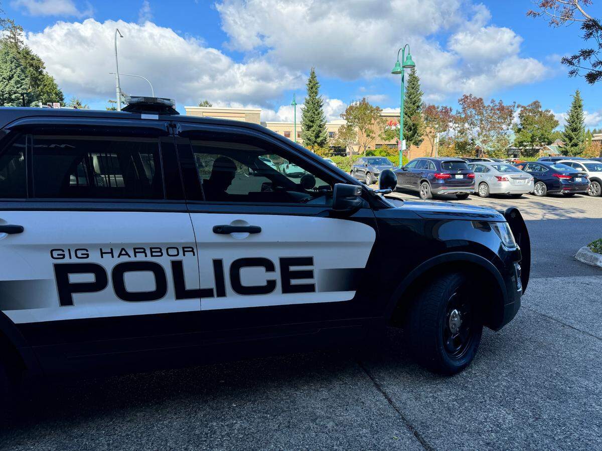 Gig Harbor Police Officer Ryan Erwin prepares to exit his vehicle in the parking lot outside Marshalls in the Uptown Gig Harbor shopping center on Thursday, Sept. 19, 2024. 