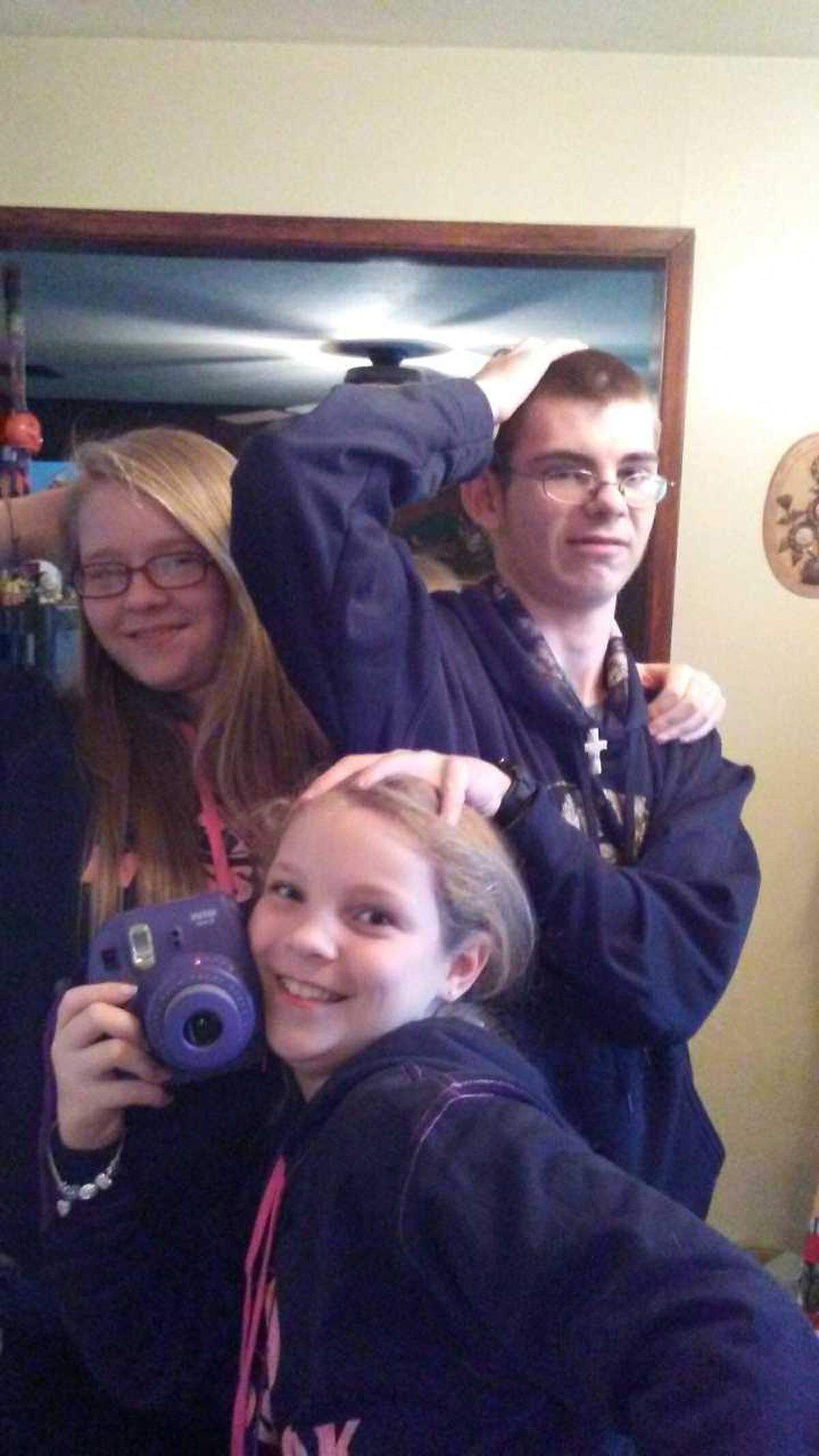 Eric J. Schachtel (right) poses for a photo with younger sisters Aryonna Ellis (center) and Brittney Schachtel.