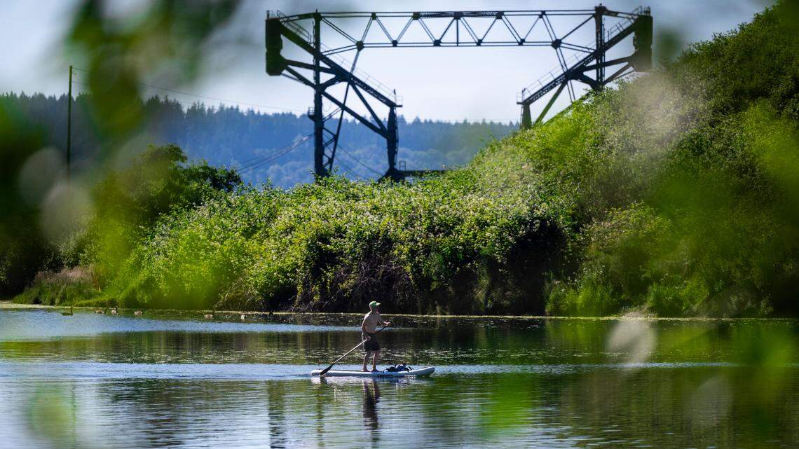 A man paddle boards on Chambers Bay in Steilacoom, Wash. on Sunday, June 26, 2022. Unseasonably high temperatures in the Puget Sound will hover in the 70s and up to low 80s for the first 11 days of October.
