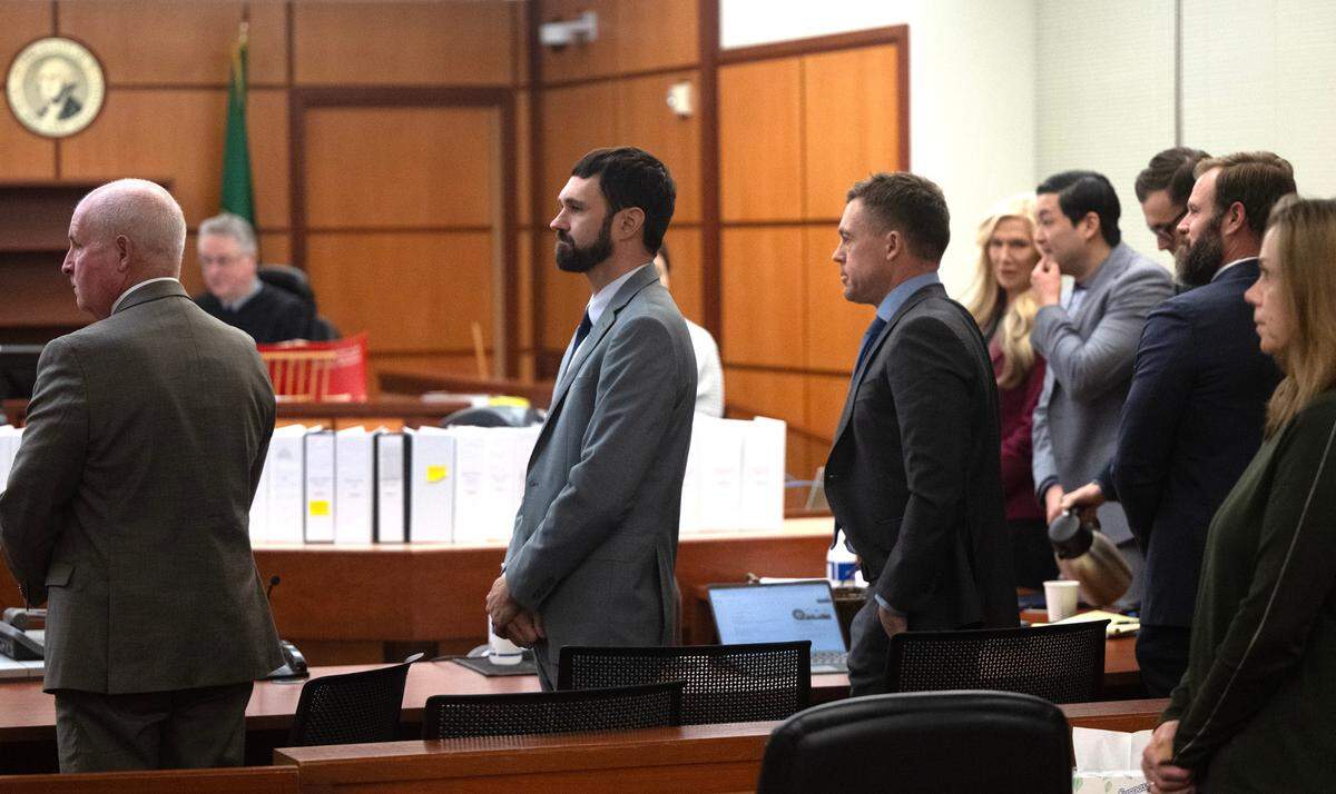 Tacoma police officers Christopher Burbank (second from left), Matthew Collins (second from right) and Timothy Rankin (fourth from right) stand with their attorneys as an alternate juror is seated during their trial in the death of Manuel Ellis on Tuesday, Dec. 19, 2023, in Pierce County Superior Court in Tacoma, Washington.