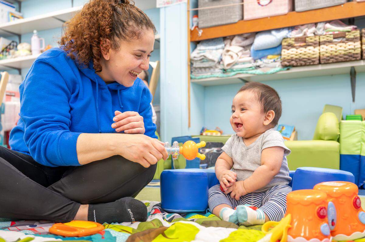 Teacher Yolanda Mendoza laughs with Early Head Start student Isaias, 8 months, as they pass a rattle between them on Friday, May 9, 2025, at the Multicultural Child and Family Hope Center in Tacoma.