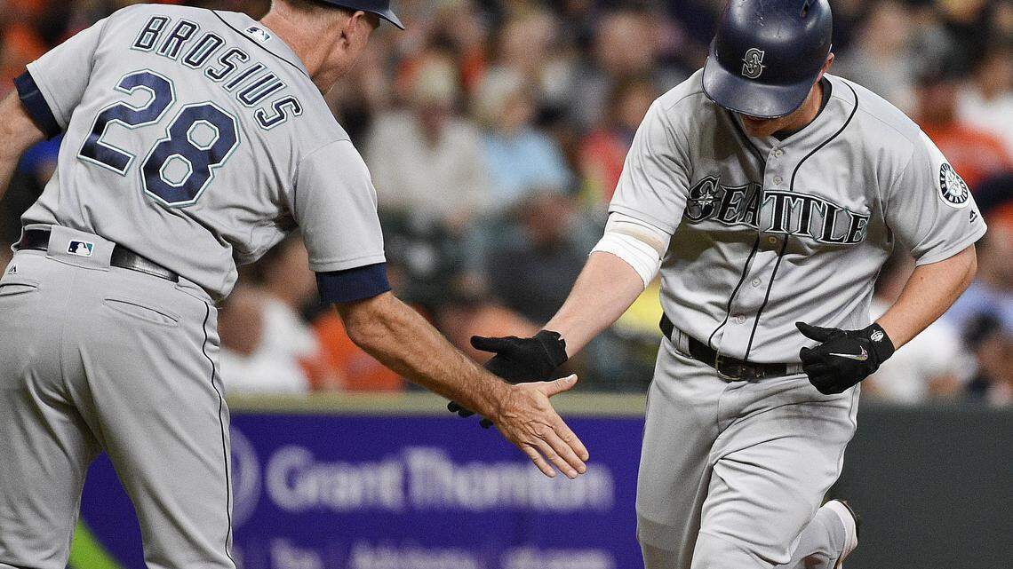 Seattle Mariners' Kyle Seager, right, shakes hands with third base coach Scott Brosius after hitting a three-run home run off Houston Astros starting pitcher Dallas Keuchel during the first inning of a baseball game Tuesday, June 5, 2018, in Houston. (AP Photo/Eric Christian Smith)