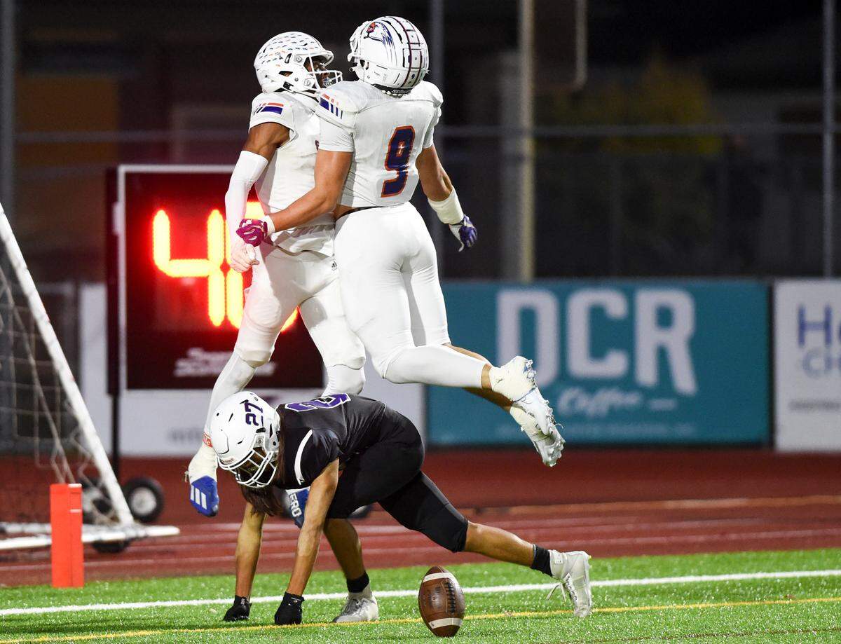 Graham-Kapowsin’s Malachi Durant (1) and Noah Flores (9) celebrate a touchdown against Sumner’s Elias Isaacs (27) during the first half of the game at Sumner High School, Thursday, Sept. 28, 2023, in Sumner, Wash.