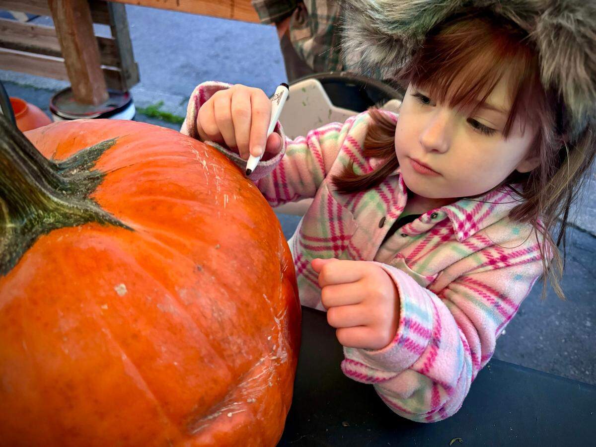 Nora Engel designs her jack-o’-lantern at the Titlow Pumpkin Patch outside The Beach Tavern in Tacoma.