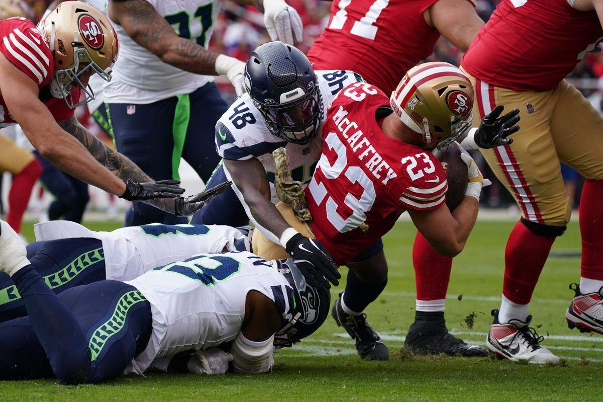 Nov 17, 2024; Santa Clara, California, USA; San Francisco 49ers running back Christian McCaffrey (23) is tackled by Seattle Seahawks linebacker Tyrice Knight (48) in the first quarter at Levi's Stadium. Mandatory Credit: David Gonzales-Imagn Images