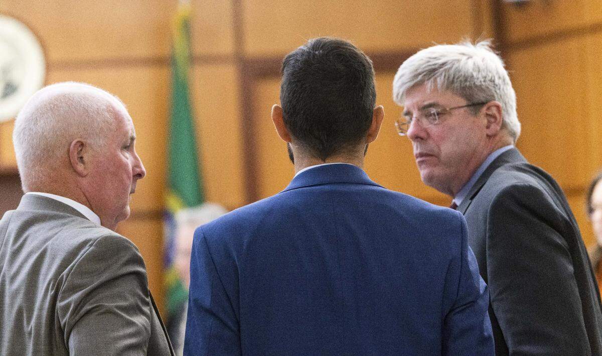 Defense attorneys Brett Purtzer, left, and Wayne Fricke, right, confer with their client, Tacoma police officer Christopher “Shane” Burbank at the trial for the death of Manny Ellis in Pierce County Superior Court on Wednesday, Oct. 4.